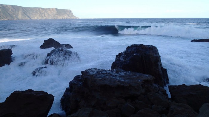 La vague de Shipstern Bluff, au fond les contreforts du cap Raoul